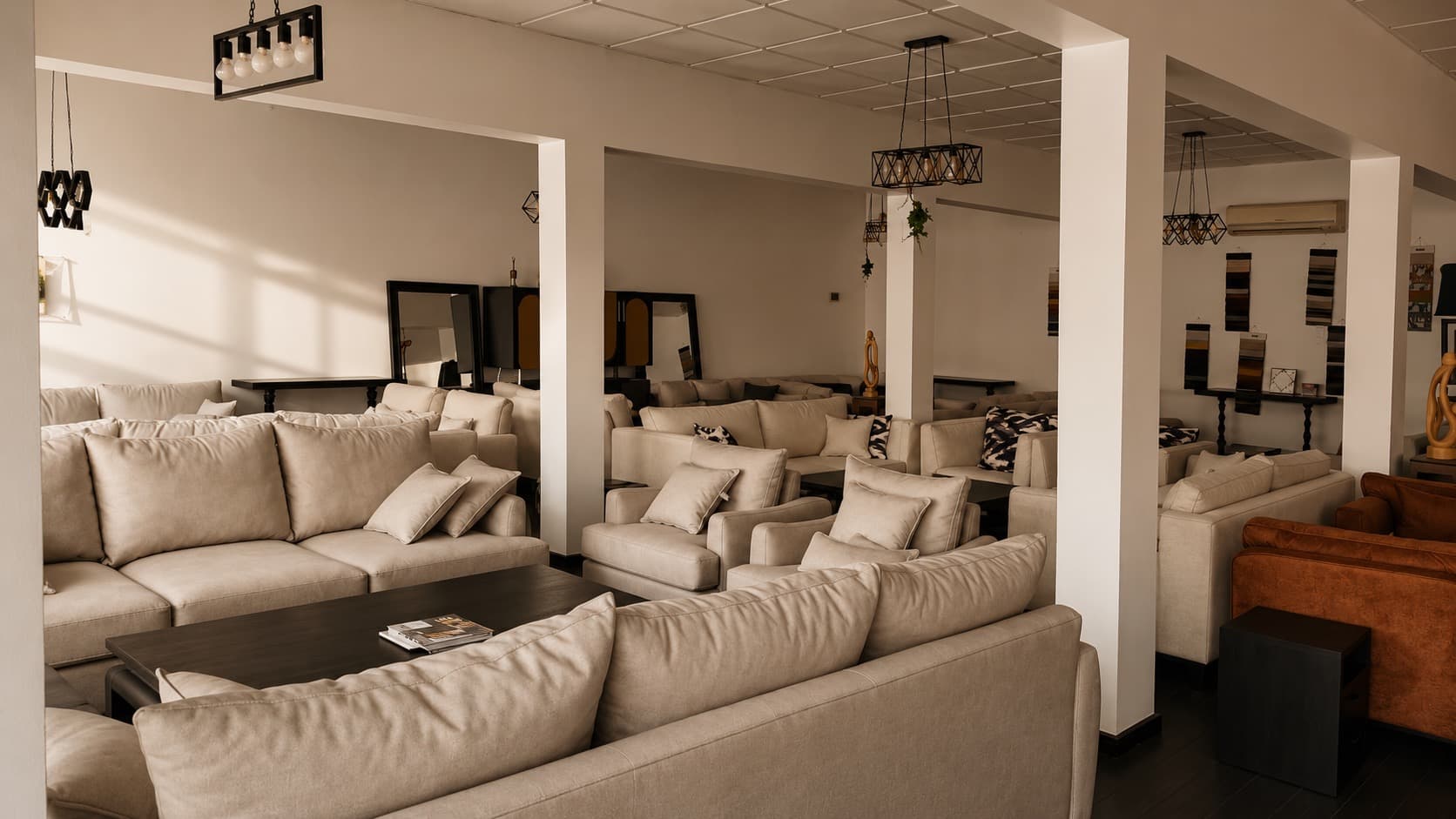 Wide view of the NDB showroom in Kigali with rows of seating suites under pendant lighting.