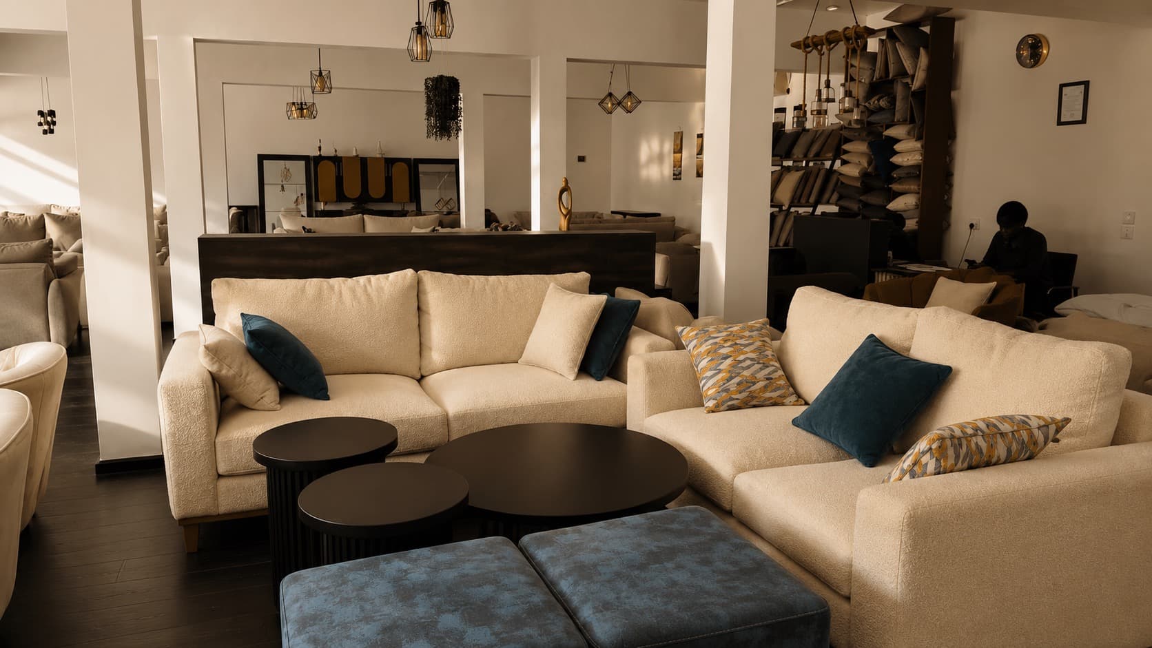 The NDB floor in Gasabo: sofa suites in progress, cushion stock racked to the ceiling, a maker at the desk.