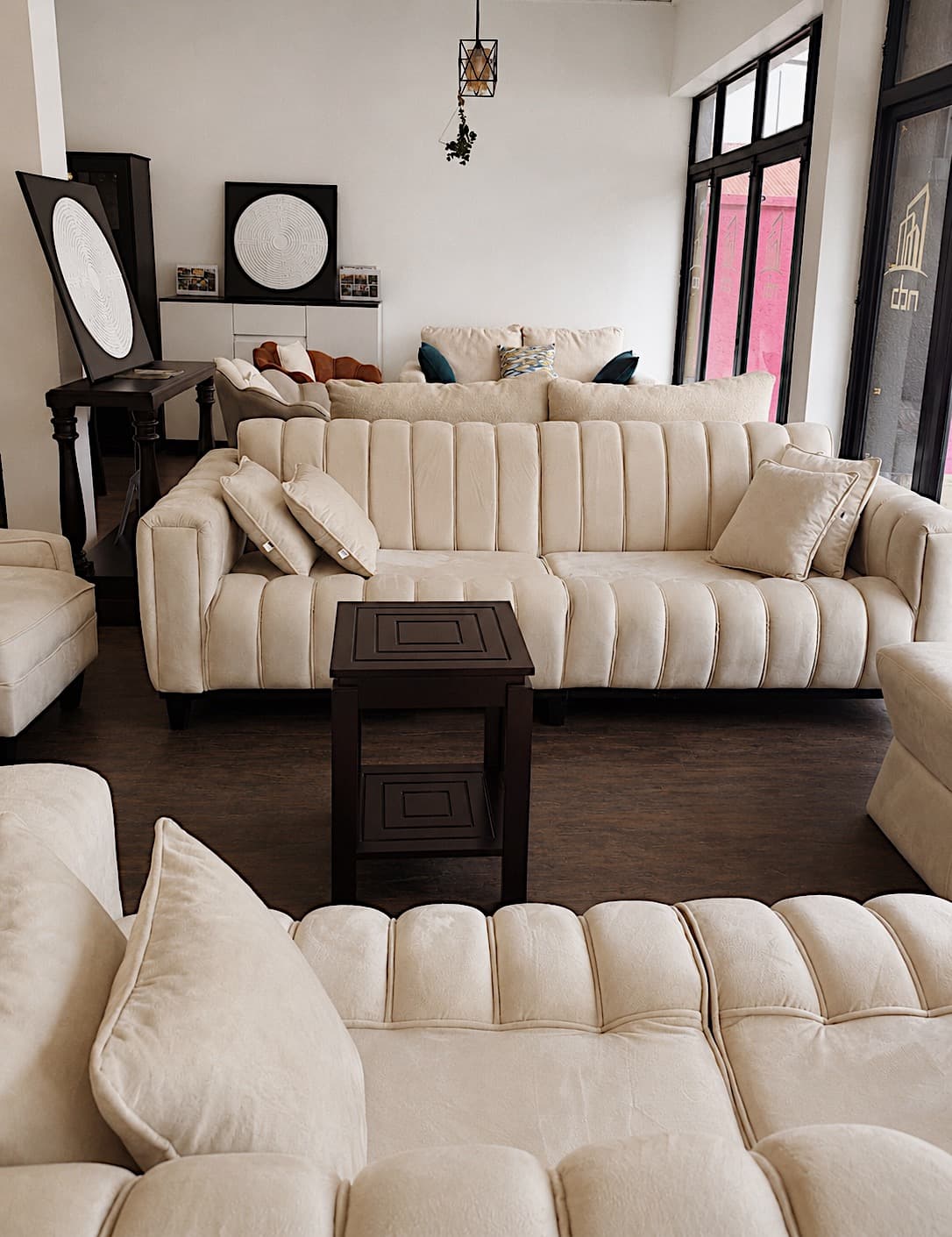 Channel-tufted cream sofa suites lined up across the NDB showroom floor in Kigali.