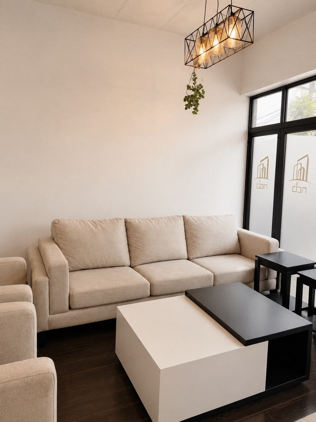 An NDB sofa suite in the Kigali showroom, beside glazing carrying the etched NDB mark.